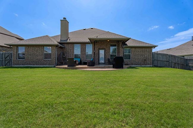 Rear view of property featuring a patio, a chimney, a fenced backyard, and brick siding | Image 27