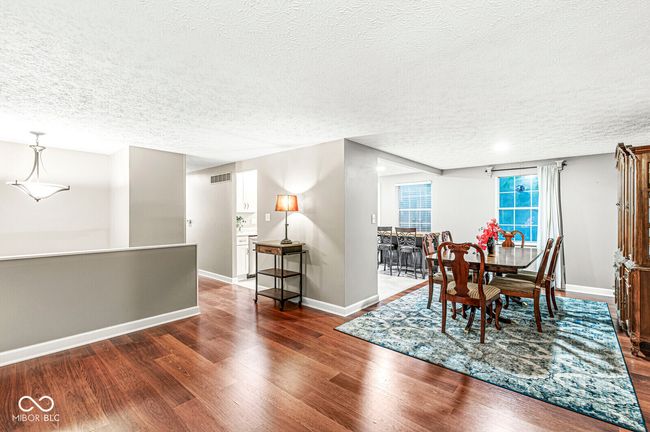 dining area with a textured ceiling and dark wood-style flooring | Image 6
