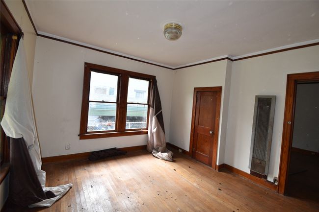 Unfurnished bedroom featuring a heating unit, light wood-style floors, and crown molding | Image 7