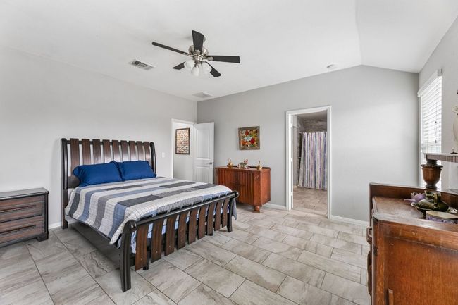 Bedroom with baseboards, visible vents, ceiling fan, and vaulted ceiling | Image 7