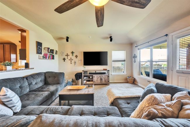 Carpeted living area featuring lofted ceiling and a ceiling fan | Image 9
