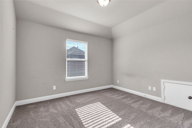 Spare room featuring carpet flooring, baseboards, and lofted ceiling | Image 25