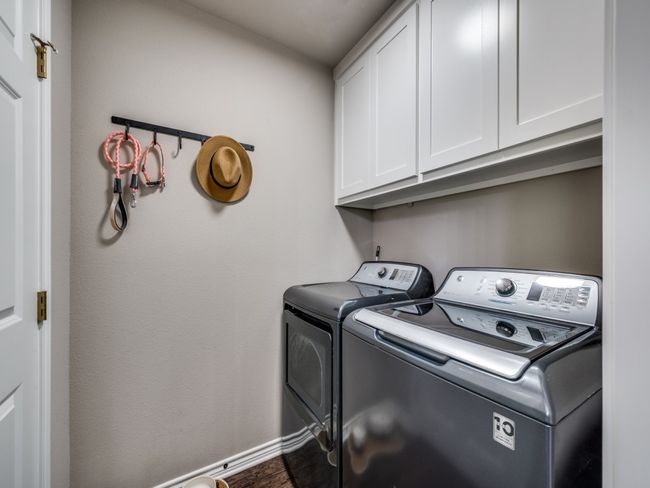 Laundry area featuring cabinet space, separate washer and dryer, and baseboards. The door on the left is to the big pantry. | Image 23