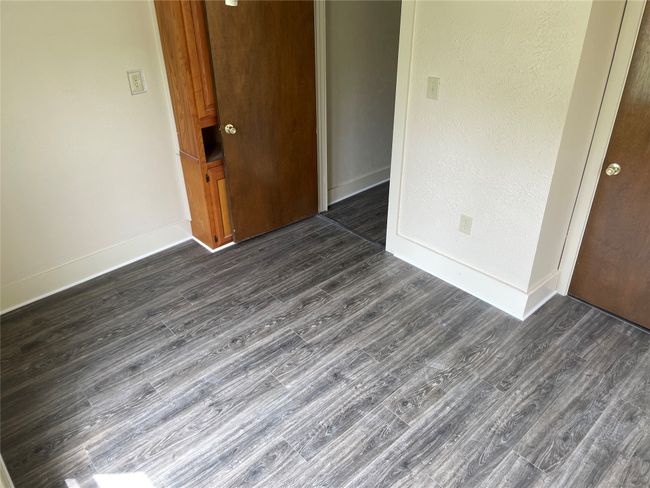 bedbedroom with dark wood-type flooring, baseboards, and a closet | Image 5