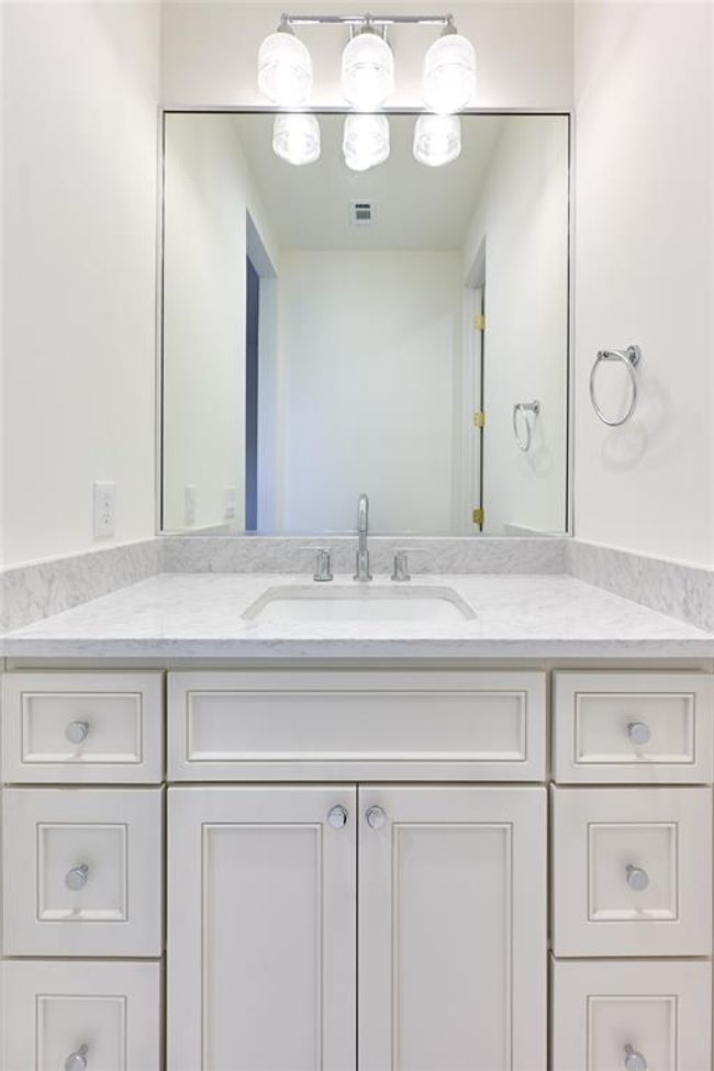 The Jack and Jill bathroom is thoughtfully designed with dual sinks, each featuring sleek quartz countertops, providing both style and practicality for shared use between the two bedrooms. | Image 43