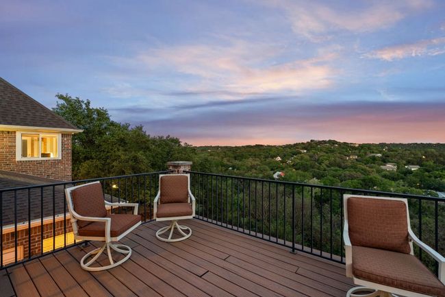Deck off of the upstairs family room at dusk overlooking The Barton Creek Greenbelt. This is the backyard view from inside and out! | Image 10
