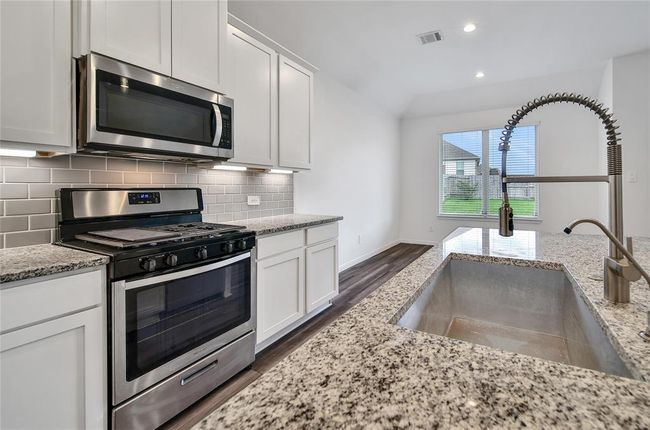 Your new kitchen boasts stainless appliances, Venetian Gold granite counters and a farmhouse style sink. | Image 14