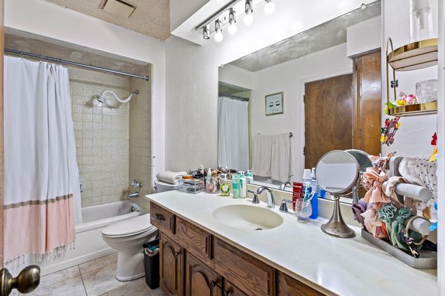 Bathroom featuring vanity, shower / tub combo with curtain, and tile patterned flooring | Image 14