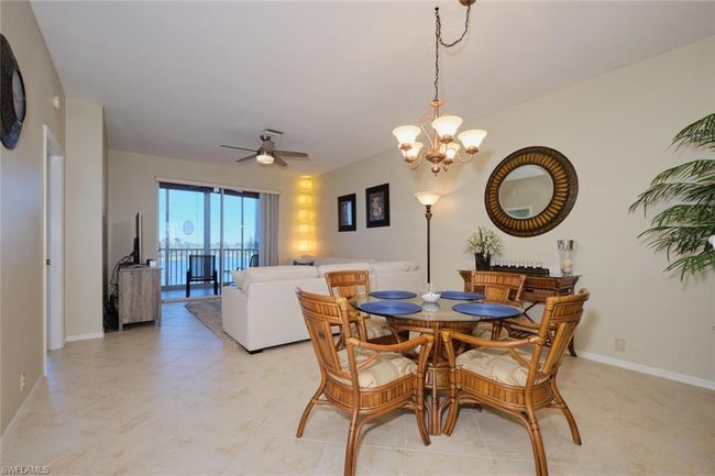 Dining space featuring ceiling fan with notable chandelier and light tile patterned flooring | Image 26