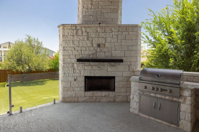 View of patio / terrace featuring an outdoor stone fireplace and area for grilling | Image 36