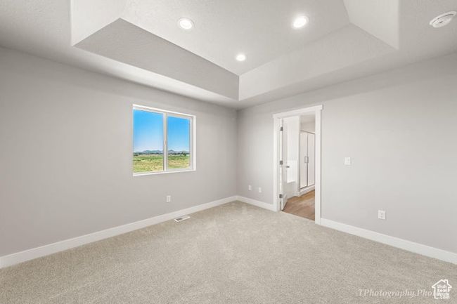 Spare room with a tray ceiling, light colored carpet, baseboards, recessed lighting, and a smoke detector | Image 15