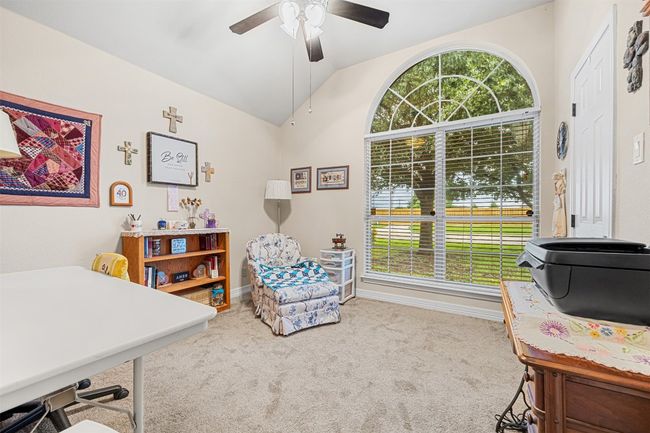 Home office with vaulted ceiling, healthy amount of natural light, carpet flooring, a ceiling fan, and baseboards | Image 23