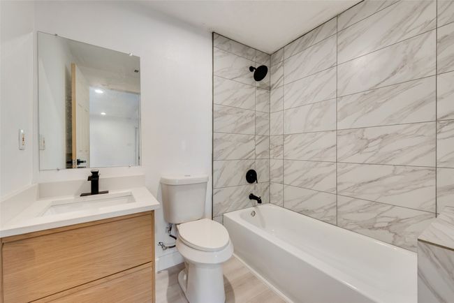 Bathroom with toilet, vanity, and washtub / shower combination | Image 14