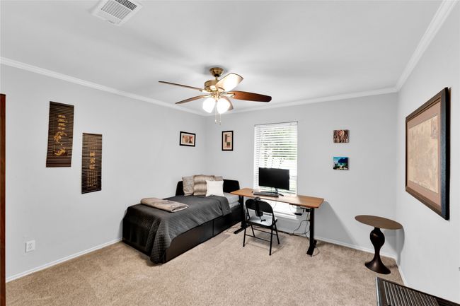 Bedroom with ornamental molding, light carpet, a desk, and a ceiling fan | Image 18