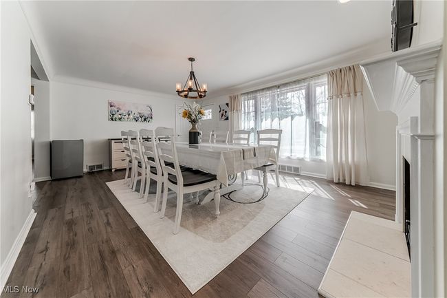Dining space with dark wood-style floors, visible vents, and an inviting chandelier | Image 8