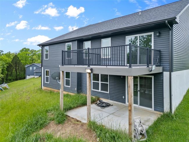 Back of property with a shingled roof, a patio area, a yard, and a balcony | Image 49
