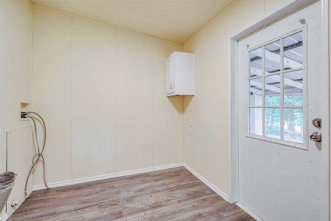 Washroom featuring cabinet space, light wood-type flooring, and hookup for a washing machine | Image 15