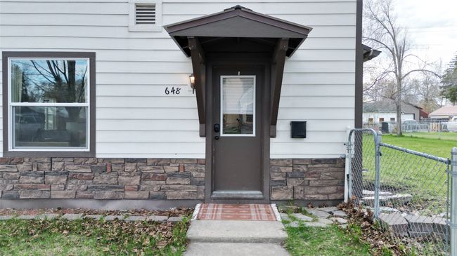 Entrance to property featuring fence and stone siding | Image 23