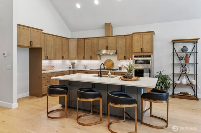 Gourmet kitchen with gas cooktop and stainless steel extraction hood. | Image 13