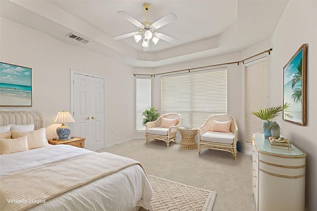 Bedroom with light carpet, a tray ceiling, and a ceiling fan | Image 26