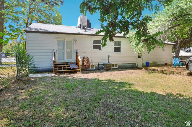 Back of house with entry steps, a wooden deck, and a chimney | Image 26