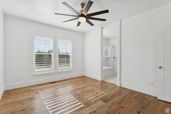 Unfurnished bedroom featuring light wood finished floors, connected bathroom, and ceiling fan | Image 13