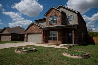 View of front of home featuring a front lawn and a garage | Image 1