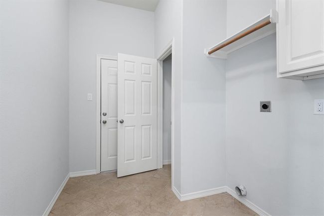 The spacious laundry room has a large closet, cabinets and hanging space. The door to the back is the pedestrian door to the garage. | Image 25
