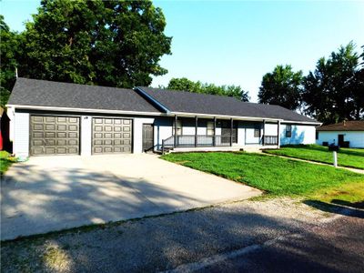 Ranch-style house featuring a porch, a garage, and a front lawn | Image 2