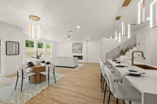 Dining area with light wood finished floors, a ceiling fan, stairs, baseboards, and recessed lighting | Image 7