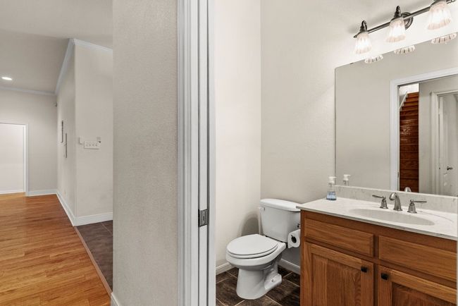 Bathroom with vanity, baseboards, ornamental molding, toilet, and wood finished floors | Image 20
