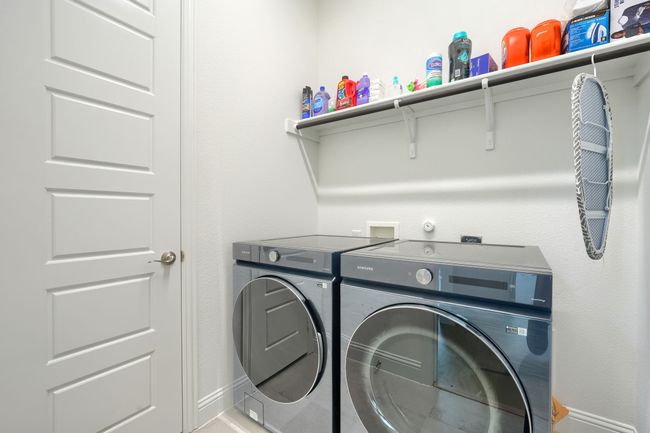 Washroom featuring washing machine and clothes dryer, laundry area, and baseboards | Image 30