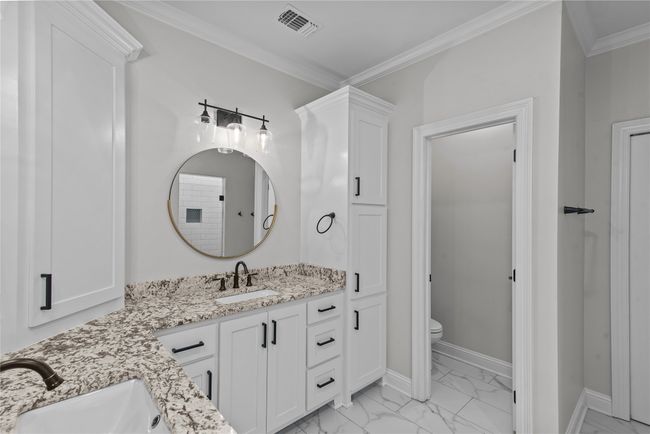 Full bathroom with marble finish floors, vanity, and ornamental molding | Image 13
