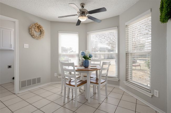 Dining area with visible vents, a textured ceiling, baseboards, and light tile patterned flooring | Image 17