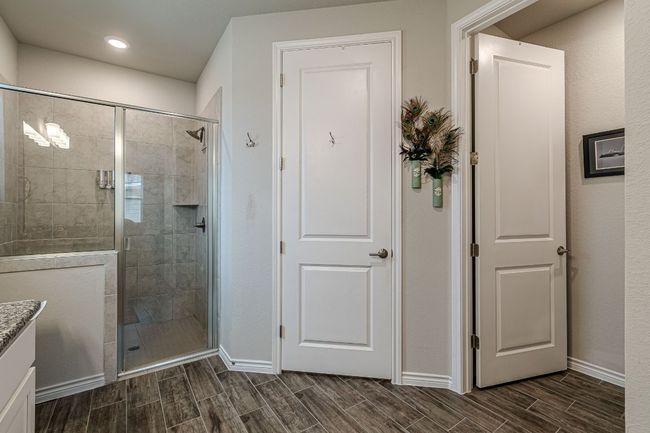 Bathroom featuring a stall shower, wood finish floors, vanity, and recessed lighting | Image 19