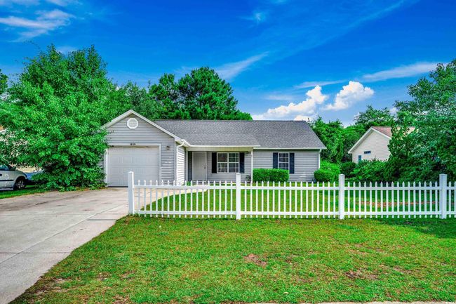 Ranch-style home with a fenced front yard, driveway, and a garage | Image 40