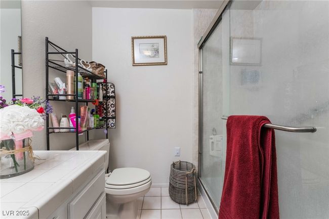 Bathroom with vanity, toilet, tile patterned flooring, and a stall shower | Image 24