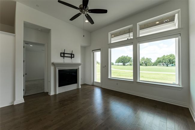 Unfurnished living room with a ceiling fan, a fireplace, dark wood-style floors, and recessed lighting | Image 31