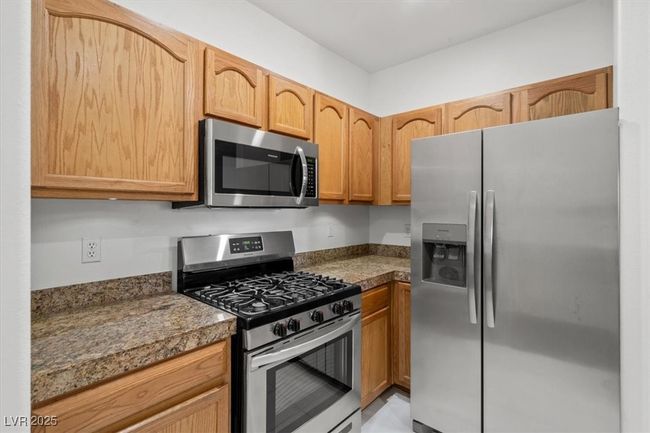 Kitchen featuring tile countertops and stainless steel appliances | Image 7