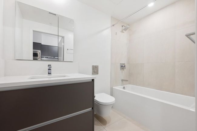 Full bathroom featuring toilet, tile patterned floors, bathing tub / shower combination, and vanity | Image 10