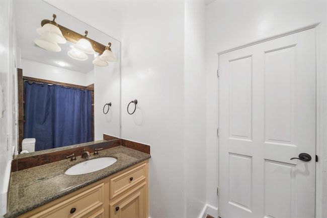 The home's third full bath is accessible from the second floor corridor with semi-private access from the second bedroom. Features included a painted cabinet with a granite counter top & tiled back splash, wall mounted mirror & lighting, a ceramic tile surrounded combination tub/shower & tile flooring. | Image 32