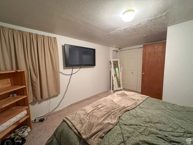 Bedroom featuring carpet, a textured ceiling, and a closet | Image 20
