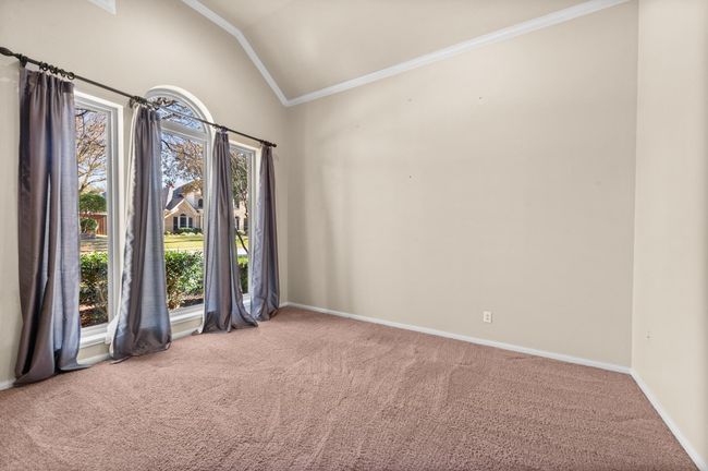 Carpeted empty room with vaulted ceiling and ornamental molding | Image 4