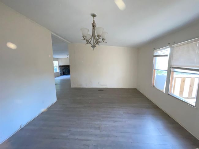 Spare room featuring a chandelier and wood finished floors | Image 23
