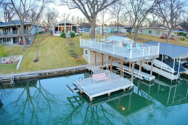 Dock area featuring stairway, a residential view, a yard, a deck, and boat lift | Image 37