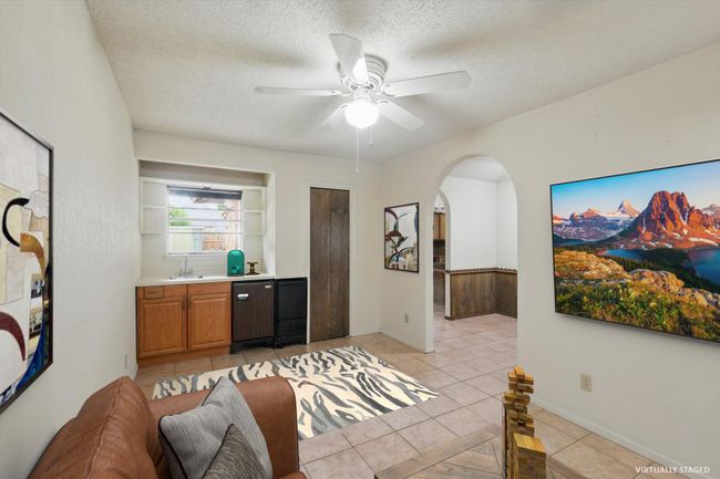sitting room featuring arched walkways, a ceiling fan, light tile patterned flooring, and a textured ceiling | Image 4
