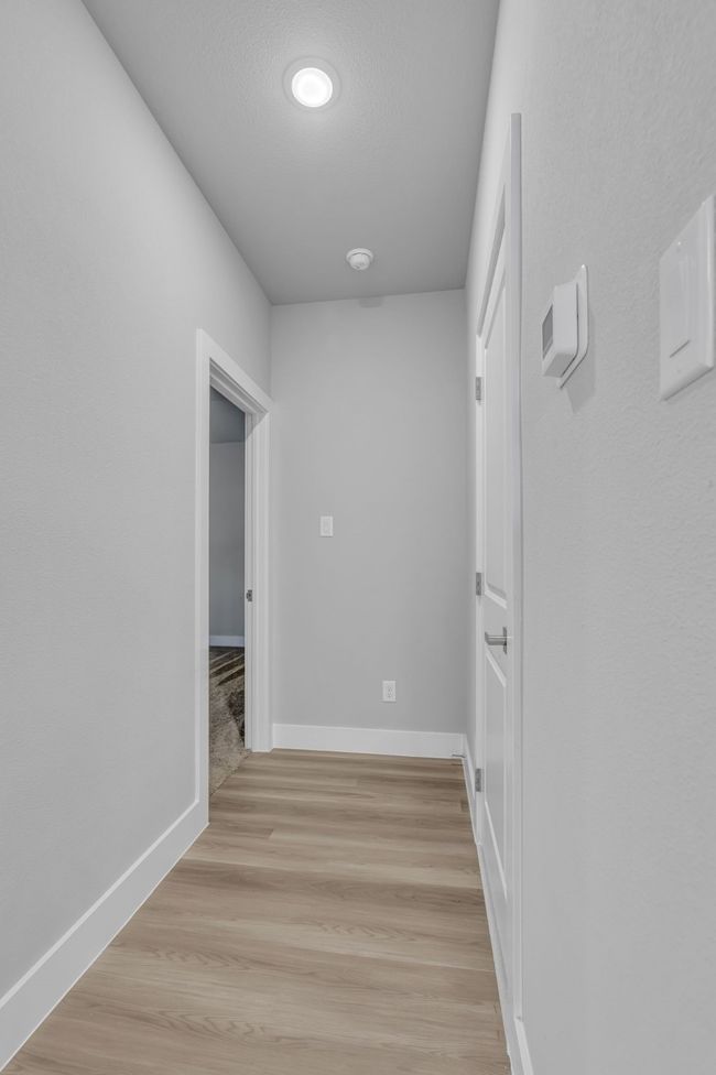 Hallway featuring baseboards, a textured ceiling, and light wood-style floors | Image 14