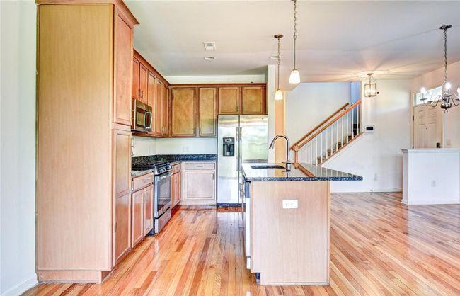 Kitchen featuring appliances with stainless steel finishes, a sink, and hardwood flooring | Image 9