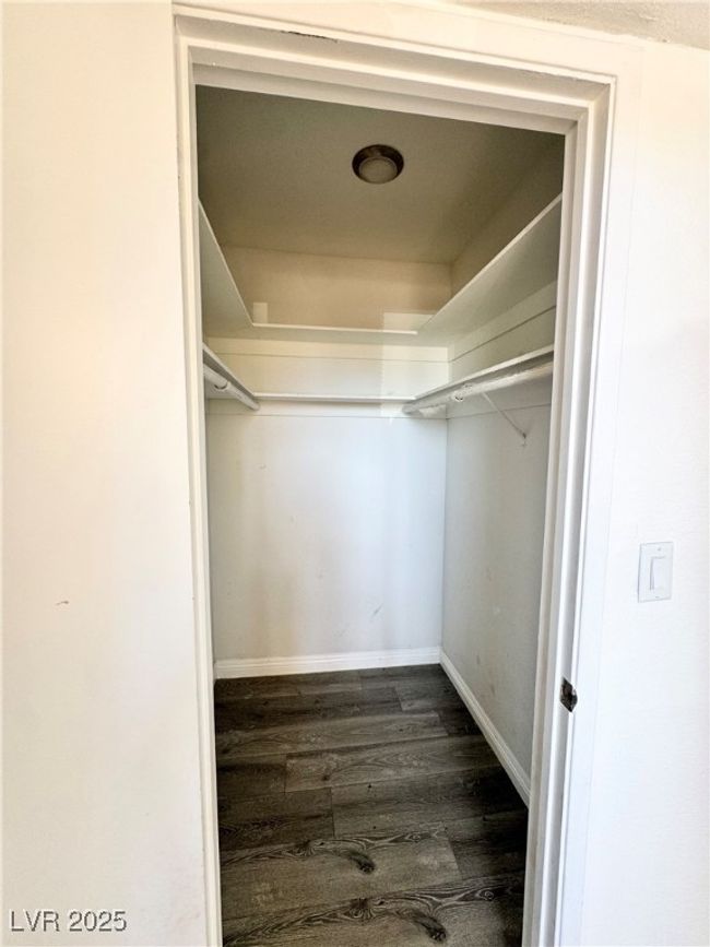 Walk in closet featuring dark wood-style floors | Image 15