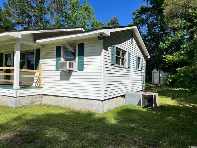 View of side of home with a lawn, a porch, and crawl space | Image 16